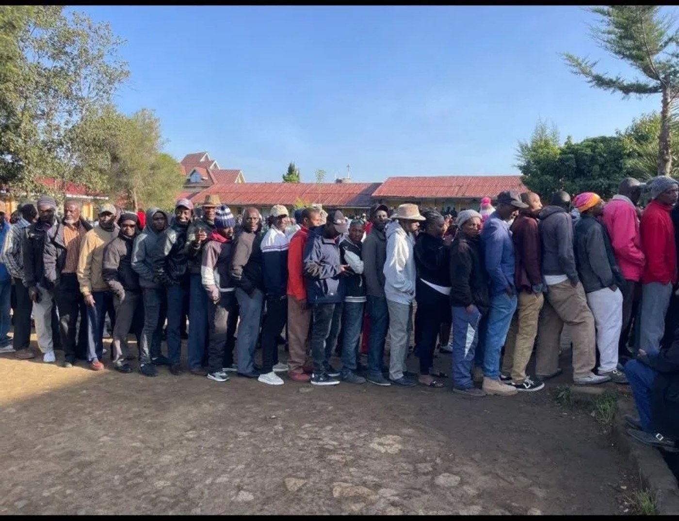 A long line of voters waits outside a school polling centre during the Ol Kalou by-election.