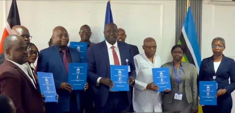 Hospital and union representatives hold blue agreement documents after the signing.