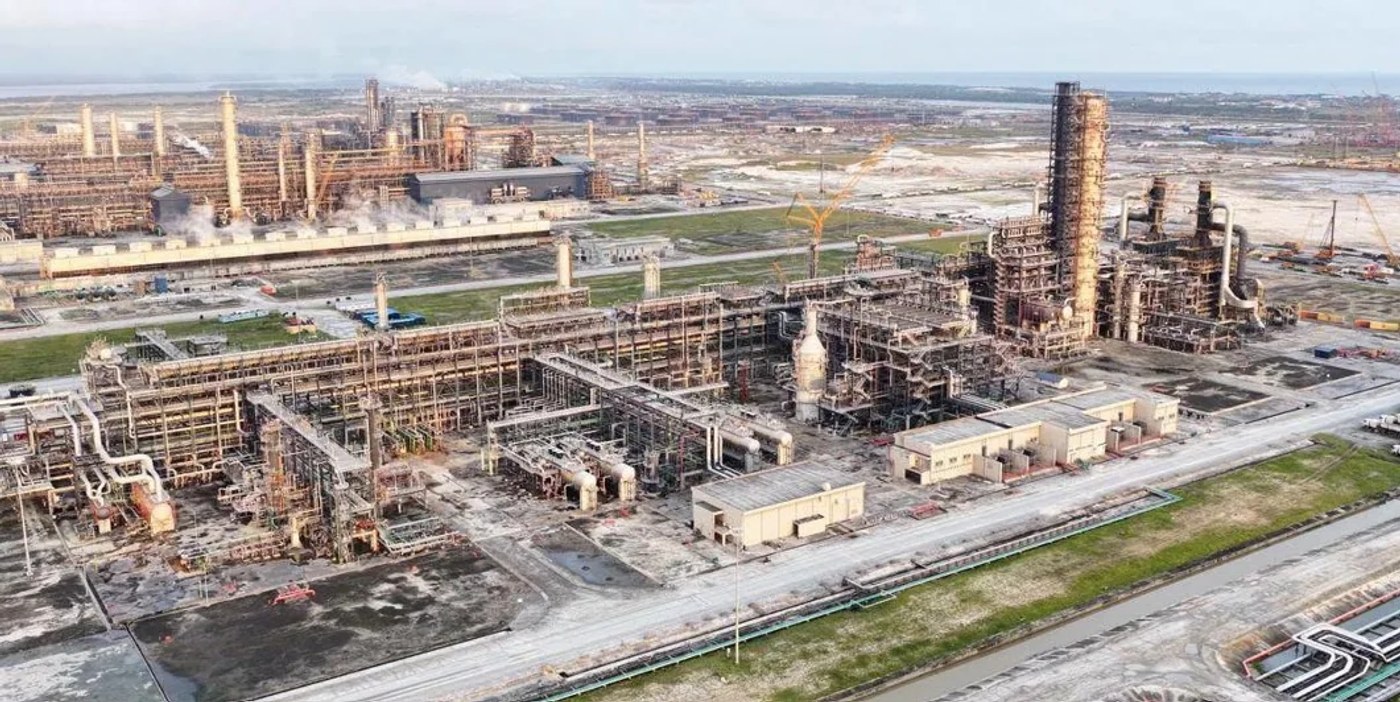Aerial view of a large oil refinery complex with towers, tanks and pipework.