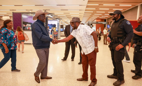 Rigathi Gachagua shakes hands with a member of the welcoming party inside an airport terminal.