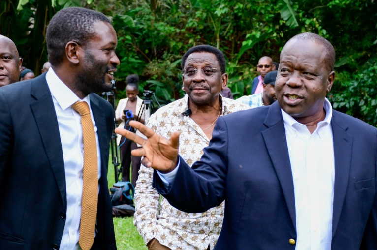 Fred Matiang’i gestures while speaking with Edwin Sifuna outdoors.